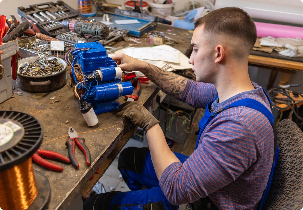 Man fixing machine in workshop.